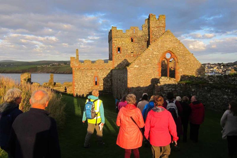 A group of walkers heading towards a ruined church building